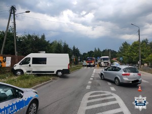pojazdy po wypadku, osobowy i bus, z lewej strony widac radiowóz w tle pojazdy