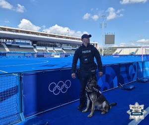 policjant z psem słuzbowym na stadionie olimpijskim we Francji