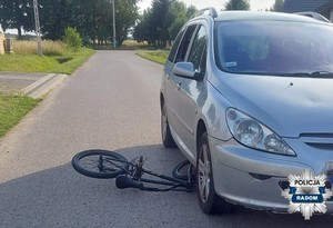 pojazd na drodze obok leży rower