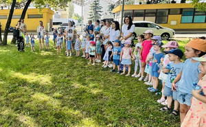 dzieci na terenie komendy miejskiej w tle budynek