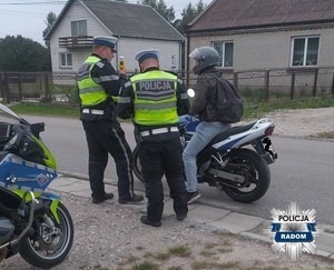 dwóch policjantów kontroluje motocyklistę