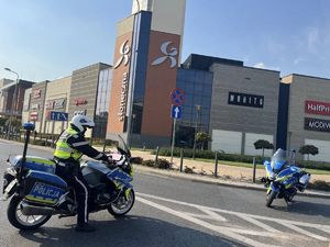 policyjne motocykle blokujące skrzyżowanie w tle budynek galerii handlowej