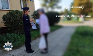 na zdjeciu przed blokiem stoi policjantka i daje ulotke seniorce w prawym rogu napis 20 pazdziernika europejski dzien seniora