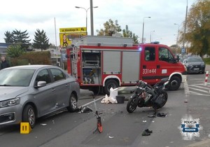 po lewej stronie pojazd po prawej motocykl w tle wóz strażacki