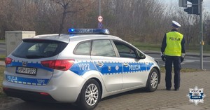 policjant stojący przy radiowozie