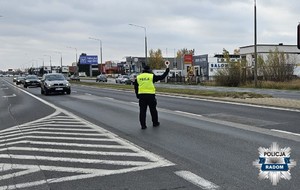 policjant na ulicy zatrzymuje ruch trzyma policyjna tarczę