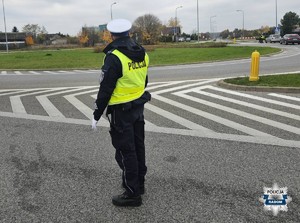 policjant stoi na ulicy zabezpiecza wjazd