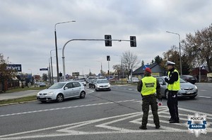 policjant i funkcjonariusz żandarmerii wojskowej stoja na skrzyzowaniu drogi dojazdowej do cmentarza