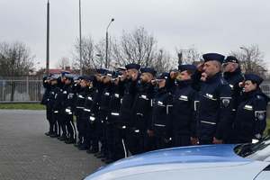 grupa policjantów przed budynkiem komendy