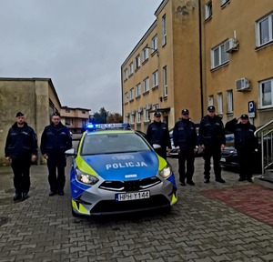 kilku policjantów przy radiowozie w tle komisariat w Skaryszewie