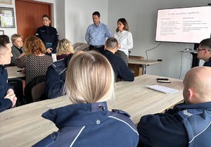 szkolenie policjantow na swietlicy, policjanci tyłem prelegenci przodem do publicznosci