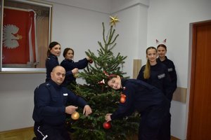 3 policjantów przy choince a po prawej stronie 3 uczennice klasy mundurowej