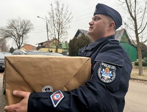 policjant trzyma w ręku paczke dla bohatera