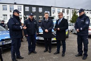 3 policjantów, starosta i wójt w tle radiowóz