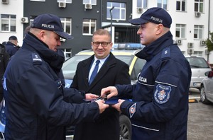 komendant przekazuje kluczyki od auta policjantowi w tle wójt gminy