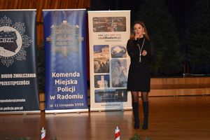 kobieta trzyma mikrofon i przemawia do uczestników spotkania