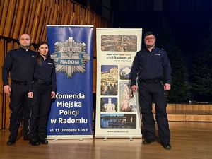 troje policjantów na cenie przy banerze  z napisem Komenda Miejska Policji w Radomiu