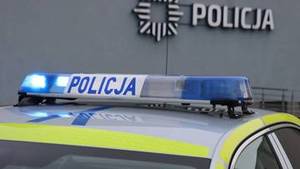 światła radiowozu w tle budynek z napisem policja