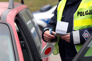 policjant kontroluje dokumenty kierowcy pojazdu