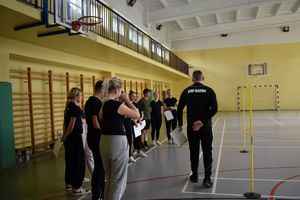policjant i uczniowie na sali gimnastycznej