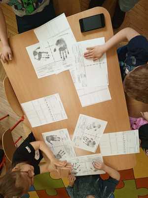 na stoliku kartki dzieci zostawiaja ślady