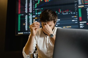 obrazek, mężczyzna przy laptopie w tle wyniki inwestycji giełdowych