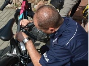 policjanta widac tyłem gdy znakuje rower