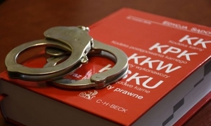 czerwony kodeks karny a na nim leża kajdanki