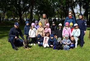 zdjęcie grupowe dzieci, opiekunki, dwoje policjantów i pies