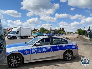 radiowóz na poboczu ulicy Wolanowskiej w tle ruch na ulicy