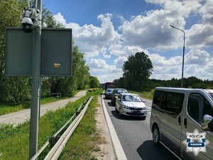 kilka pojazdów na ulicy na słupie widac zamontowana policyjna kamerę