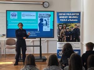 policjantka a za nia ekran z informacjami o kampani oraz roll up komendy
