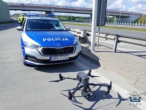 radiowóz a przed nim policyjny dron