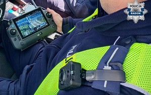 ekran policyjnego drona w dłoni policjanta siedzacego w radiowozie