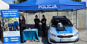 namiot profilaktyczny policji banery radiowóz w środku dwie policjantki