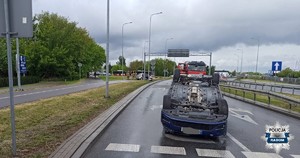 miejsce wypadku , pojazd na dachu w tle inny uszkodzony pojazd przy słupie