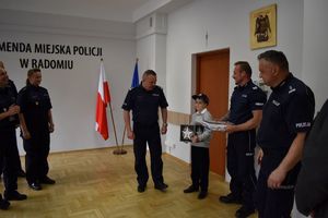 grupa policjantów i kilkuletni chłopiec na świetlicy