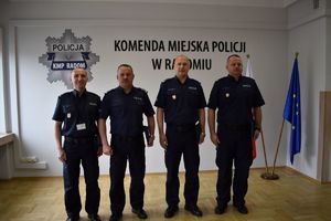 czterech policjantów na sali 3 z nich trzyma granatowe teczki