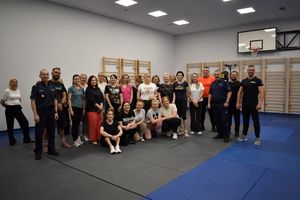 zdjęcie grupowe pracownice policji, instruktorzy, policjanci na sali gimnastycznej