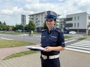 Policjantka w czapce stoi w rejonie przejścia dla pieszych.