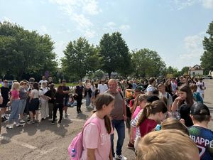Duża ilość młodzieży i uczniów stoi na parkingu przy ulicy Warszawskiej w Radomiu.