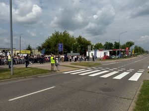 Na zdjęciu znajduje się droga, ulica warszawska. W tle są dzieci oraz młodzież.