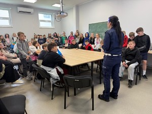 w sali w komendzie uczniowie  i tyłem stoi policjantka