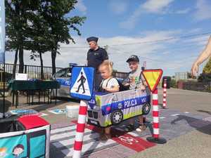 policjant mini miasteczko ruchu drogowego oraz dwoje dzieci