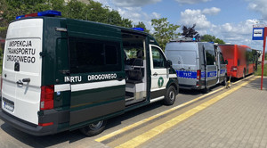 pojazd inspekcji ruchu drogowego, policji w tle czerwony autokar
