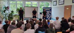 troje policjantów na sali podczas spotkania z uczniami