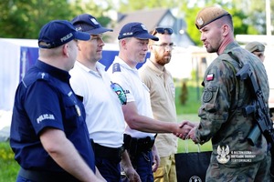 policjanci i żółnierze podają sobie dłoń