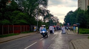 policyjny motocykl na ulicy podczas zabezpieczenia procesji, w tle uczestnicy