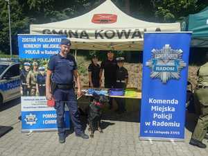 policjanci i pies służbowy przy stoisku profilaktycznym