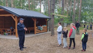 policjant i grupa dzieci na spotkaniu w lesie